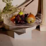 An elegant Alabaster Serving Bowl with a matte finish, filled with fruits like grapes and pears, placed on a stone surface.