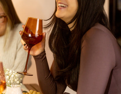 A photo of a Dani holding a glass of wine in a Saludi glass.